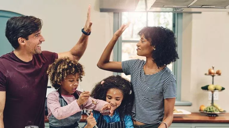 Parents high-fiving while children are engaged in an activity.